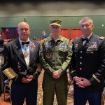 Living history re-enactor in uniform with event attendees.