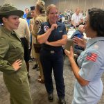 Volunteers in uniform speak with Thunderbirds Sq. member.