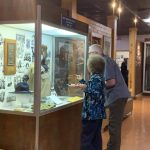 Airman Heritage Foundation Secretary, Joan Lopez, showcases a display in which her father is highlighted.