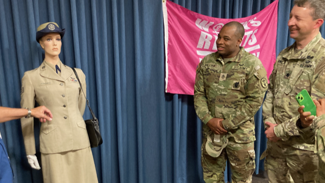 Soldiers at JBSA-Fort Sam Houston look over a USAF women's uniform know as "Silver Tans" during the Women's Equality Day event.