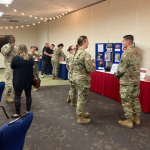 Attendees review collages and memorabilia during Women's Equality Day event at JBSA-Fort Sam Houston.